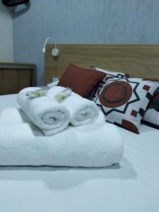 a bed with white towels on top of it at Chapada Confort Flats in Alto Paraíso de Goiás