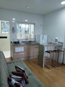 uma sala de estar com um sofá e uma cozinha em Chapada Confort Flats em Alto Paraíso de Goiás