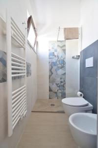 a white bathroom with a toilet and a sink at Family Room Scicli in Scicli