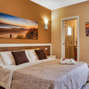una camera da letto con un grande letto e un dipinto sul muro di La Perla delle Dune (Sul Mare) a Porto Cesareo