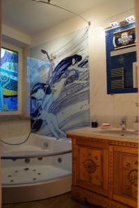 a bathroom with a bath tub and a painting on the wall at Apartment "Gustav Klimt" in Zell am See
