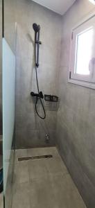 W łazience z przeszklonymi drzwiami znajduje się prysznic. w obiekcie Xenophon Suite at National Opera SNFCC Park w Atenach