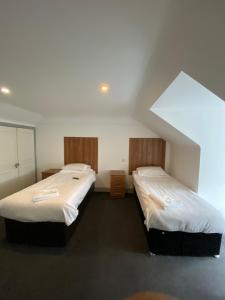 two beds are in a room with at Contractors Guest House in High Wycombe