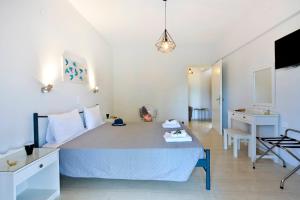a bedroom with a large bed and a desk at Kalliopi Apartments in Roda