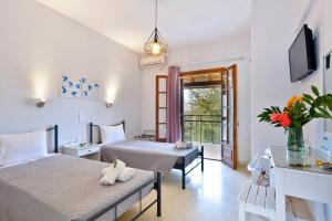 a hotel room with two beds and a balcony at Kalliopi Apartments in Roda