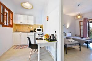 een keuken met een tafel en een stoel in een kamer bij Kalliopi Apartments in Roda