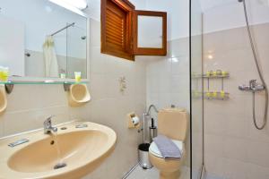 a bathroom with a sink and a shower at Kalliopi Apartments in Roda +45 photos