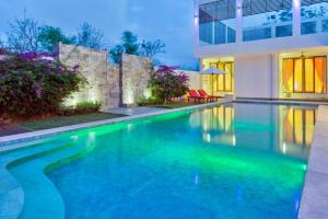 a swimming pool in front of a house at Sunset Villa in Jimbaran