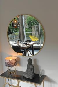 a mirror on a wall with a table and a dining room at Les Briochines - Cocon cosy en plein centre-ville in Saint-Brieuc