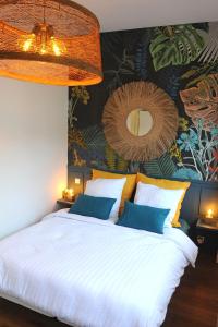 ein Schlafzimmer mit einem großen weißen Bett und einem Wandbild in der Unterkunft Les Briochines - Cocon cosy en plein centre-ville in Saint-Brieuc