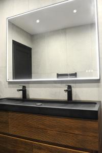 ein Badezimmer mit einem schwarzen Waschbecken und einem Spiegel in der Unterkunft Les Briochines - Cocon cosy en plein centre-ville in Saint-Brieuc + 28 Fotos