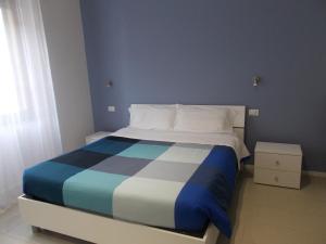 1 dormitorio con 1 cama azul y blanco en Il Giardino di Anna - Charming rooms in Cagliari en Cagliari