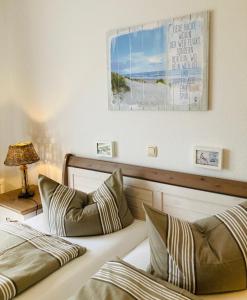 a bedroom with two beds and a picture on the wall at Strandkojen in Trassenheide