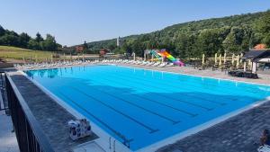 a large swimming pool with blue water and chairs at Seoski Turiziam Larva in Trenkovo