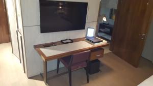 a desk in a room with a television on the wall at Fendi Private Suites - Small Luxury Hotels of the World in Rome