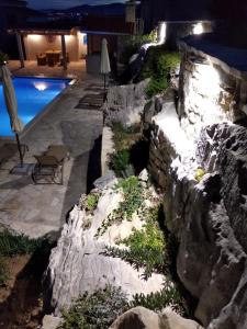 a rock retaining wall next to a swimming pool at night at Apartment MareLux in Kaštela