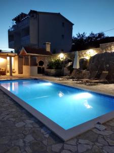 a swimming pool in a villa at night at Apartment MareLux in Kaštela