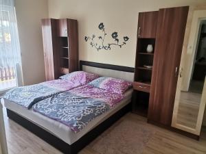 A bed or beds in a room at Lea apartman