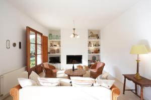 ein Wohnzimmer mit einem weißen Sofa und Stühlen in der Unterkunft Finca la Querida, Idylle auf dem Land in Campos