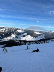 a group of people on snowboards on a snow covered mountain at Apartment MyMara No3 in Bešeňová