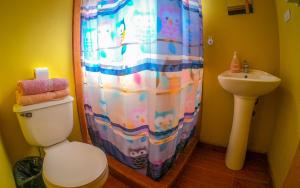 a bathroom with a shower curtain and a toilet and a sink at La Casa del Sol Naciente in San Pedro de Atacama +37 photos