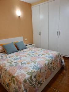 Un dormitorio con una cama con una colcha floral. en Apartamento Ana en Playa de Santiago, en Playa de Santiago