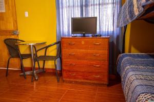 a bedroom with a dresser with a television on it at La Casa del Sol Naciente in San Pedro de Atacama