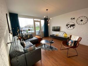 een woonkamer met een bank en een stoel bij IJsvogel Apartment, Duplex Family Home 4-bed located on the largest saltwater lake in Bruinisse