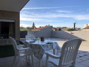 a table with white chairs sitting on a patio at Quinta das Oliveiras in Moimenta da Serra +6 photos