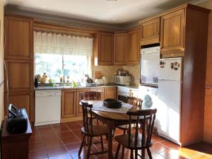 a kitchen with wooden cabinets and a table with chairs at Quinta das Oliveiras in Moimenta da Serra