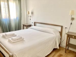 - une chambre avec un lit blanc et 2 serviettes dans l'établissement Moderno apartamento en San Bartolomé, à Séville
