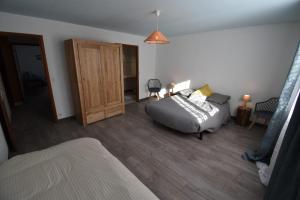 a bedroom with a bed and a wooden floor at Le Vallon des âmes - Large house for 15 people in Roubion in Névache