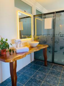 La salle de bains est pourvue d'un lavabo et d'un miroir. dans l'établissement Suíte frente mar e pés na areia, à Japaratinga