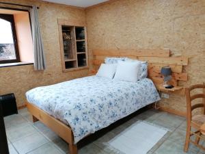een slaapkamer met een bed, een tafel en een raam bij Couettes et Picotin in Durbuy