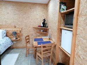 a small room with a table and chairs and a bed at Couettes et Picotin in Durbuy