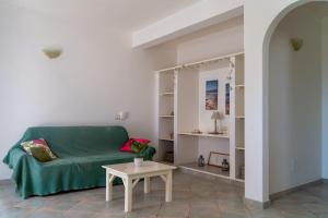 a living room with a green couch and a table at Lovely beach front apartment in Santa Maria in Santa Maria
