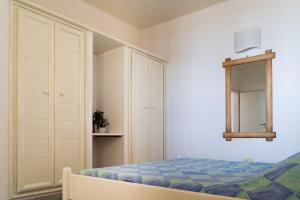 a bedroom with a bed and a dresser and a mirror at Lovely beach front apartment in Santa Maria in Santa Maria