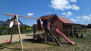 um parque infantil com um baloiço num quintal em Słowińskie Widoki domek Natura, noclegi Smołdziński Las em Smoldziński Las