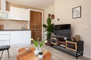 a living room with a television and a table at Beach Break Deco & Sleeping in Katwijk aan Zee