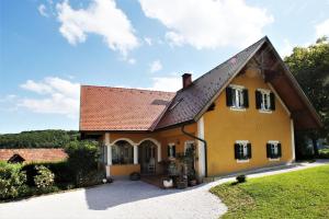 żółty dom z brązowym dachem w obiekcie Weingut - Ferienhaus Sonja Rohrbacher w mieście Gamlitz