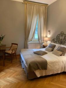 um quarto com uma cama, uma mesa e uma janela em Villa Mimosa au Lac - Estella Hotels Italia em Toscolano Maderno