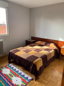 1 dormitorio con cama y alfombra en el suelo en LA CASA DE REYES - WIFI Gratis, en León