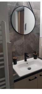 La salle de bains est pourvue d'un lavabo et d'un miroir mural. dans l'établissement ArtStudio, à Braşov