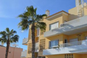 un edificio con palmeras delante en Apartamentos Cabanas Golf en Tavira