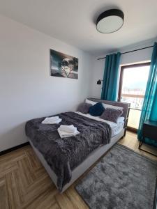 Un dormitorio con una cama grande y una ventana en Apartament Lake View z sauną i widokiem na jezioro en Kluszkowce
