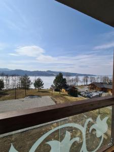 vista sull'acqua dalla finestra di una casa di Apartament Lake View z sauną i widokiem na jezioro a Kluszkowce