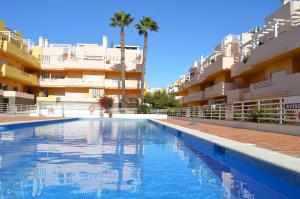 a swimming pool in front of some apartment buildings at Apartamentos Cabanas Golf in Tavira
