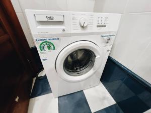 a washing machine in a room with a tile floor at Kyiv Gallery Apartment in Kyiv