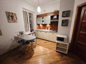 a kitchen with a table and chairs and a microwave at Kyiv Gallery Apartment in Kyiv