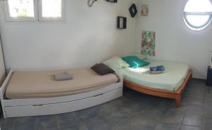 two twin beds in a room with a window at VILLA CAP détente et SPA in Saint-Louis +9 photos
